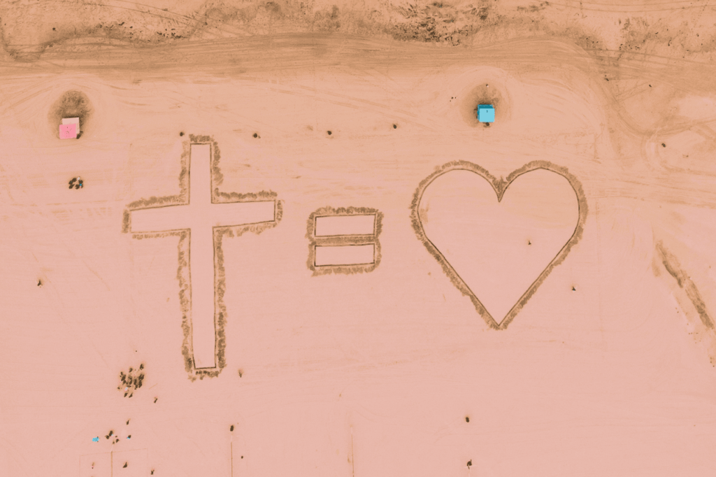tomar a sua cruz é viver o amor de Cristo desenhado na areia